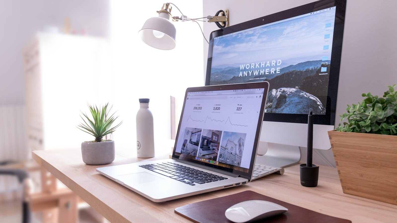 MacBook Pro on table beside white iMac and Magic Mouse